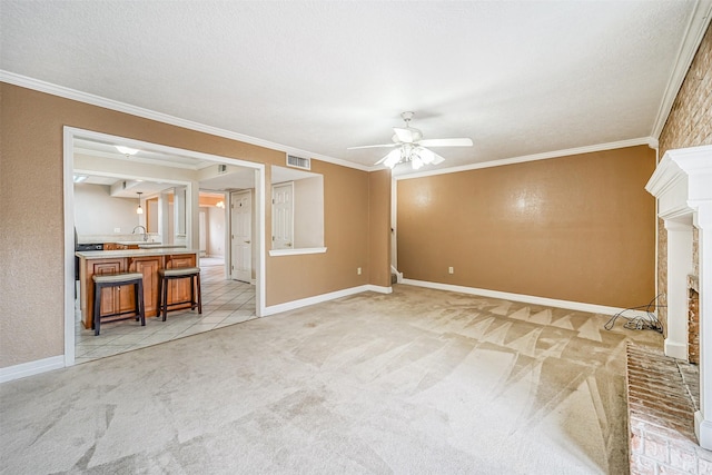 unfurnished living room with visible vents, ornamental molding, a ceiling fan, and light colored carpet