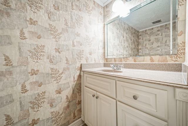 bathroom with wallpapered walls, visible vents, ornamental molding, and vanity