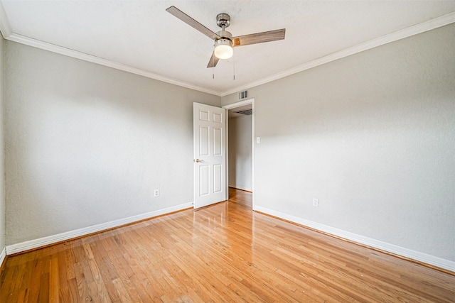 spare room featuring a ceiling fan, light wood-style flooring, baseboards, and crown molding