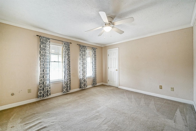 carpeted empty room featuring baseboards, ornamental molding, ceiling fan, and a textured ceiling