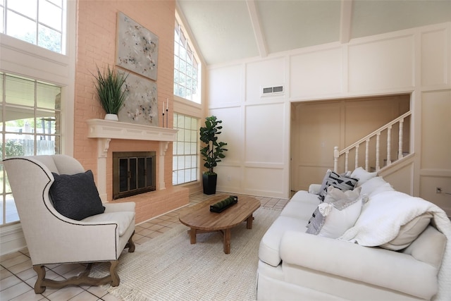 living room featuring a wealth of natural light, visible vents, and a decorative wall