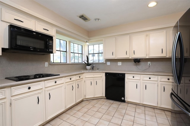 kitchen featuring black appliances, light countertops, visible vents, and white cabinets