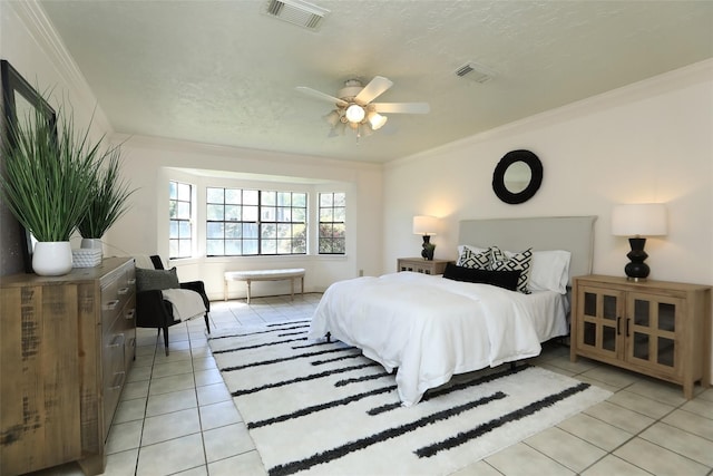 bedroom featuring ornamental molding, visible vents, a textured ceiling, and light tile patterned floors