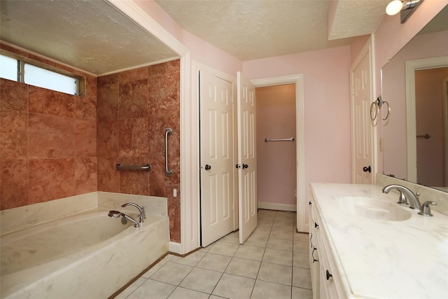 full bathroom with a textured ceiling, vanity, a tub, baseboards, and tile patterned floors