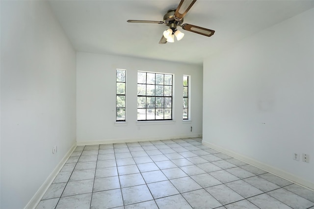 spare room featuring light tile patterned floors, baseboards, and a ceiling fan