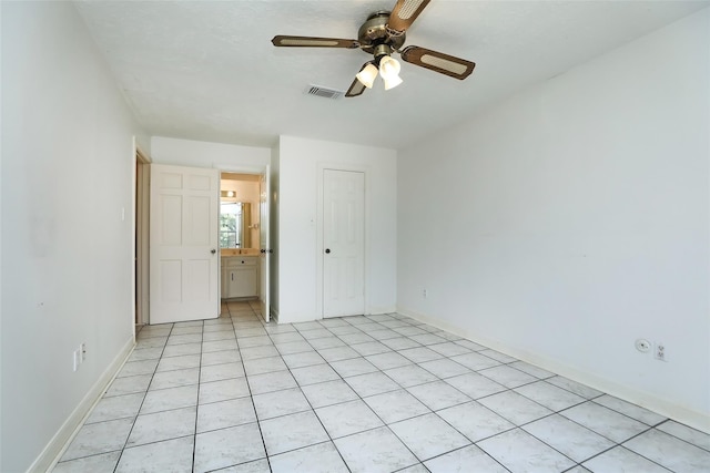 unfurnished bedroom featuring light tile patterned floors, visible vents, baseboards, a ceiling fan, and a closet