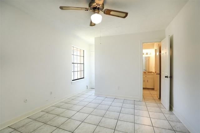 unfurnished room with light tile patterned floors, a ceiling fan, and baseboards