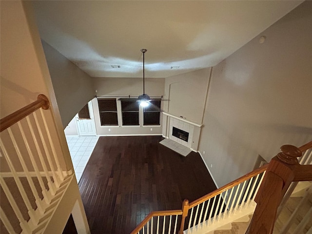 stairway featuring a tile fireplace and wood finished floors