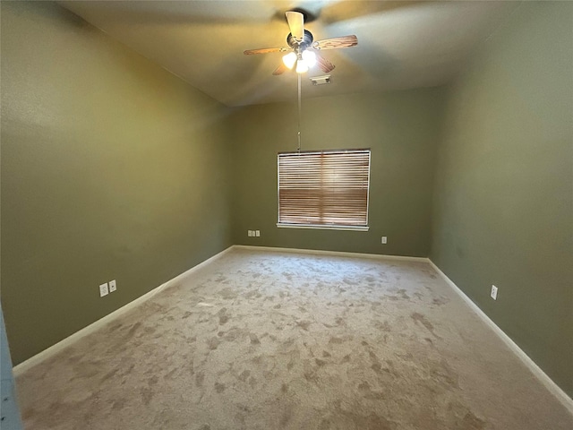 empty room with carpet floors, visible vents, ceiling fan, and baseboards