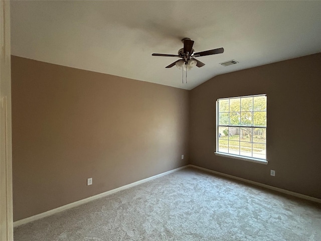 unfurnished room featuring lofted ceiling, carpet floors, visible vents, and baseboards