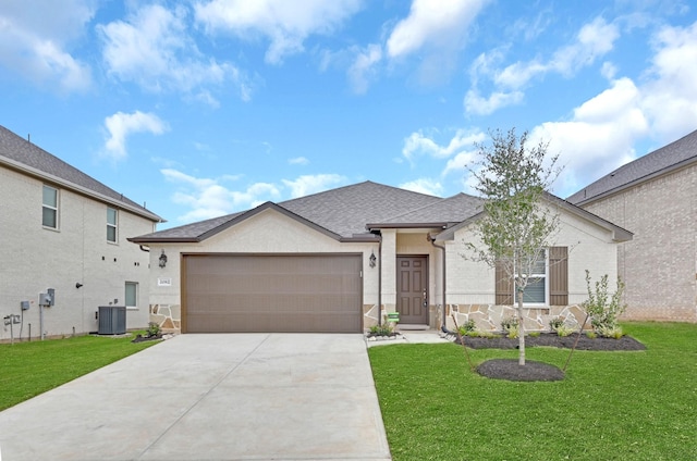 ranch-style house with central air condition unit, a shingled roof, concrete driveway, an attached garage, and a front yard