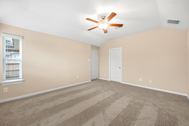 spare room with visible vents, baseboards, ceiling fan, carpet, and vaulted ceiling