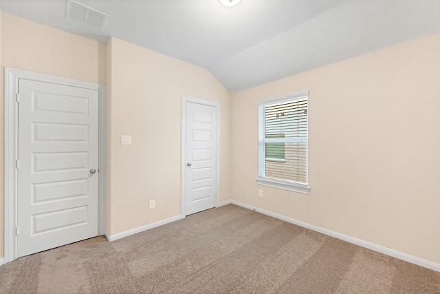 interior space with vaulted ceiling, carpet, visible vents, and baseboards