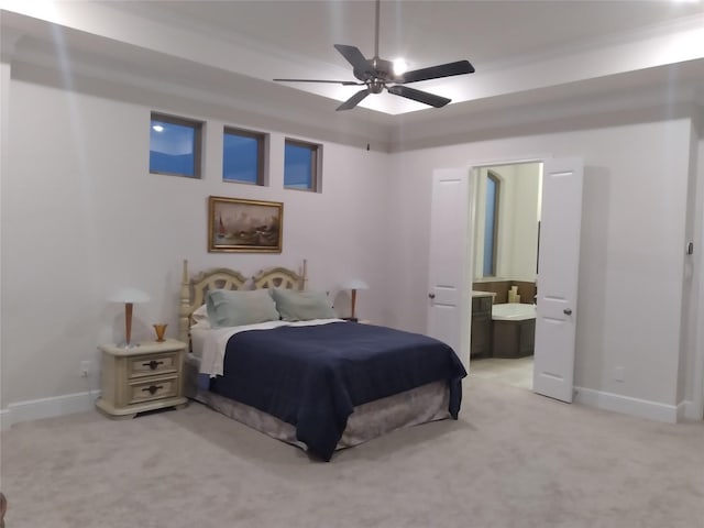 bedroom with light colored carpet, ceiling fan, ensuite bath, and baseboards