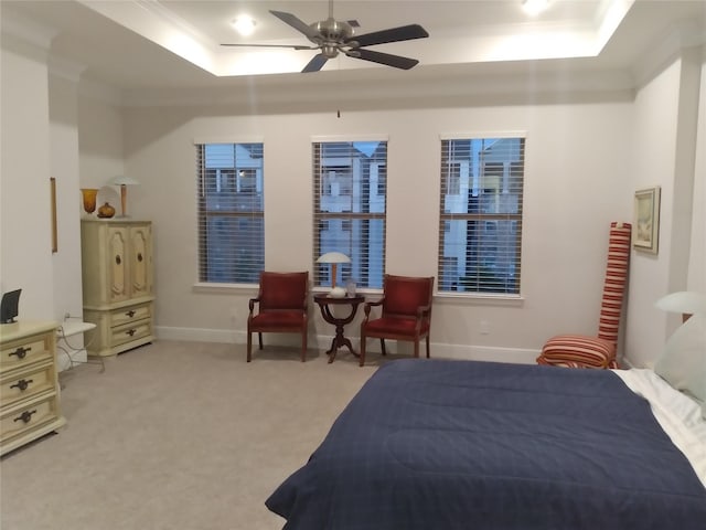 bedroom with ornamental molding, a raised ceiling, light carpet, and baseboards