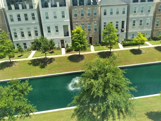 view of community with a lawn and a water view