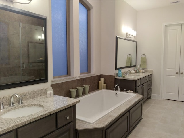 bathroom with a bath, a stall shower, two vanities, and a sink