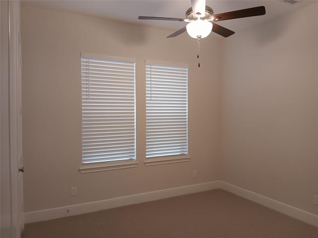 empty room featuring visible vents, carpet, a ceiling fan, and baseboards