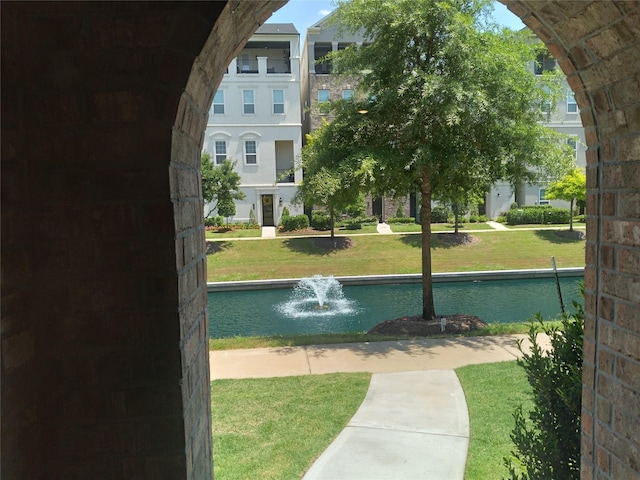 view of community featuring a yard and a water view