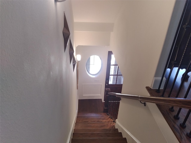 staircase featuring baseboards and wood finished floors