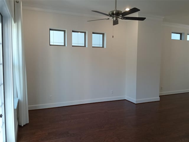 empty room with dark wood-style floors, baseboards, and ornamental molding