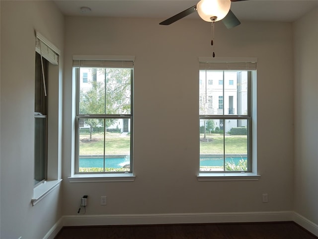 spare room featuring baseboards, a ceiling fan, and a healthy amount of sunlight