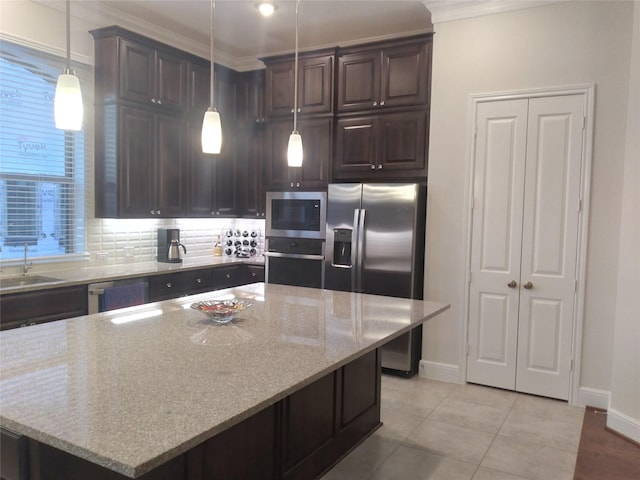 kitchen featuring light tile patterned floors, dark brown cabinetry, appliances with stainless steel finishes, light stone countertops, and crown molding