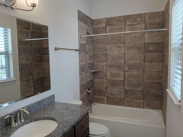 bathroom with washtub / shower combination, vanity, and toilet