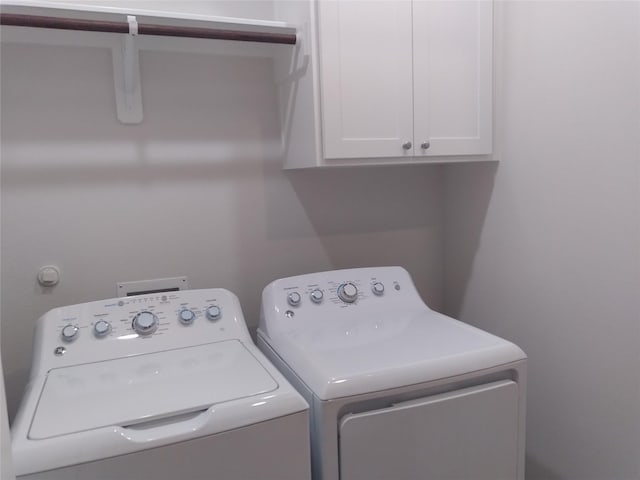 laundry area featuring separate washer and dryer and cabinet space