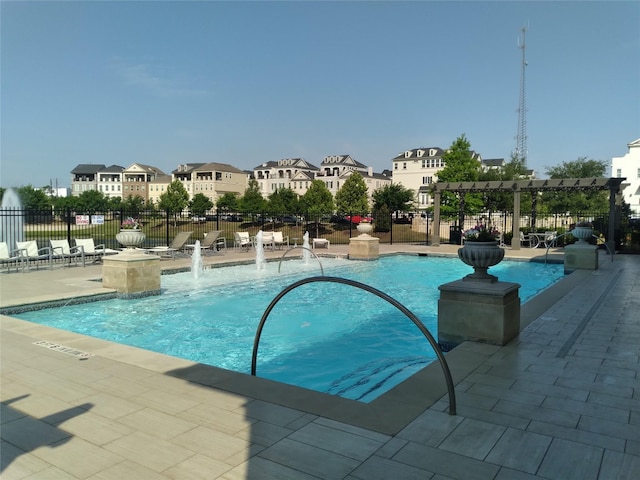 community pool featuring a residential view, a patio area, and fence