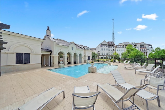 pool with a patio and fence