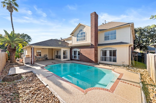 view of swimming pool featuring a fenced in pool, a fenced backyard, a patio, and area for grilling