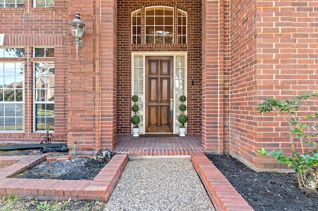 doorway to property featuring brick siding