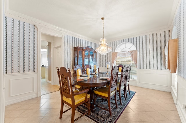 dining room featuring wallpapered walls, crown molding, and wainscoting