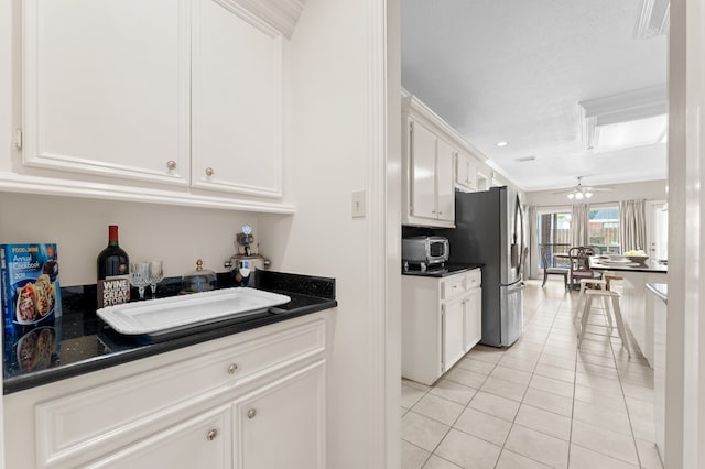 kitchen featuring light tile patterned flooring, a sink, white cabinetry, and stainless steel fridge with ice dispenser