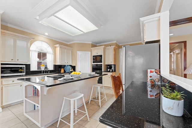 kitchen with a center island, light tile patterned floors, backsplash, appliances with stainless steel finishes, and a kitchen breakfast bar