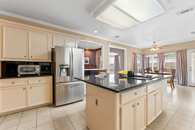 kitchen featuring black stovetop, stainless steel refrigerator with ice dispenser, cream cabinets, and light tile patterned floors