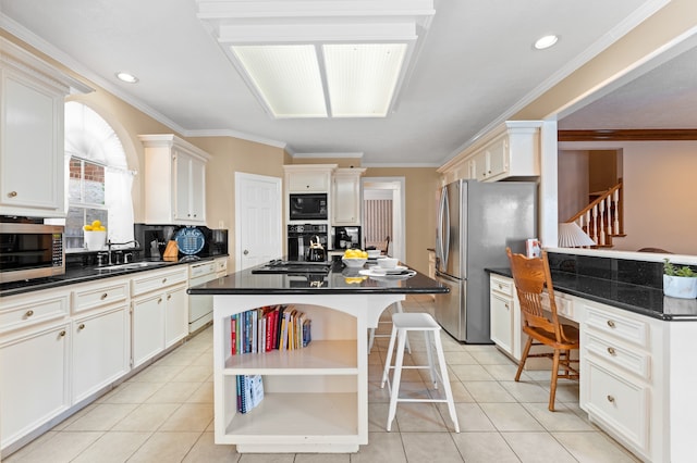 kitchen featuring dark countertops, a kitchen breakfast bar, black appliances, and light tile patterned floors