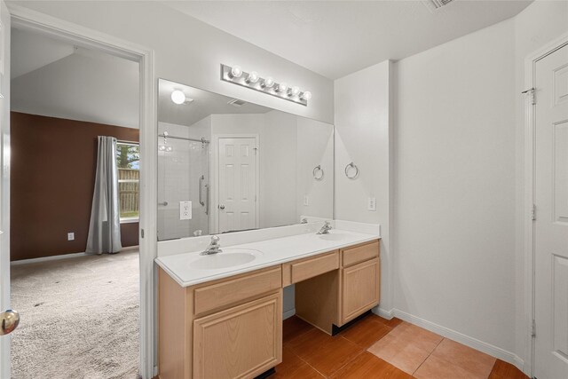 full bath featuring double vanity, a shower, a sink, and baseboards