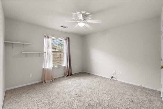 spare room with carpet, visible vents, ceiling fan, and baseboards