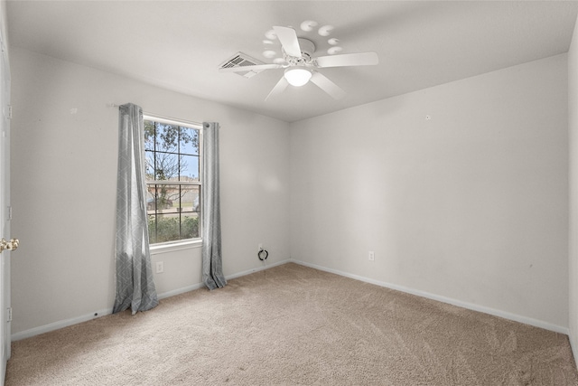 carpeted spare room featuring a ceiling fan and baseboards