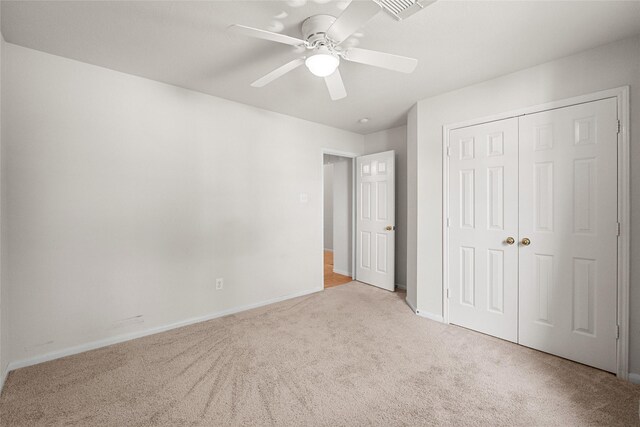 unfurnished bedroom featuring baseboards, visible vents, ceiling fan, carpet flooring, and a closet