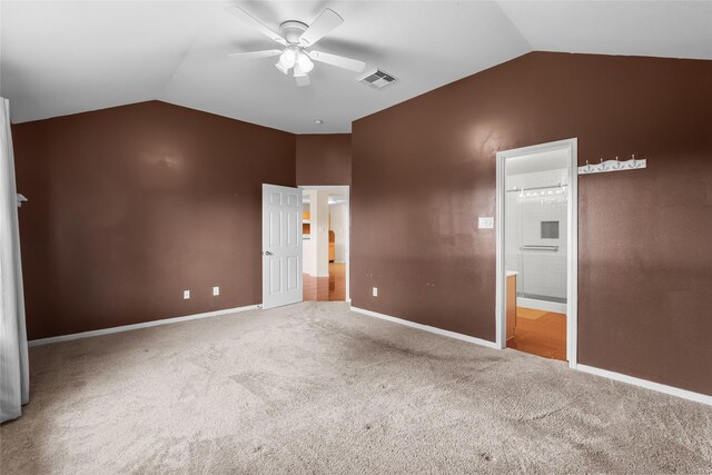 unfurnished bedroom featuring carpet floors, visible vents, vaulted ceiling, and ensuite bathroom