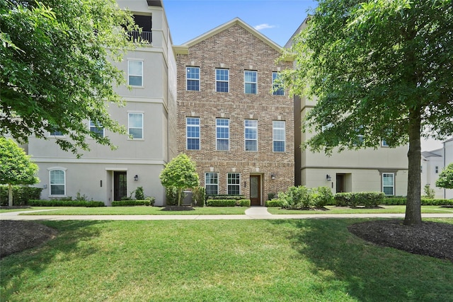 multi unit property with a front lawn, central AC unit, and brick siding