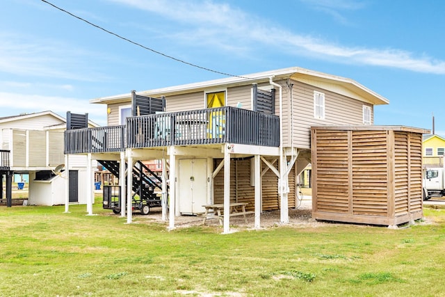 back of property featuring a deck, a yard, and stairway