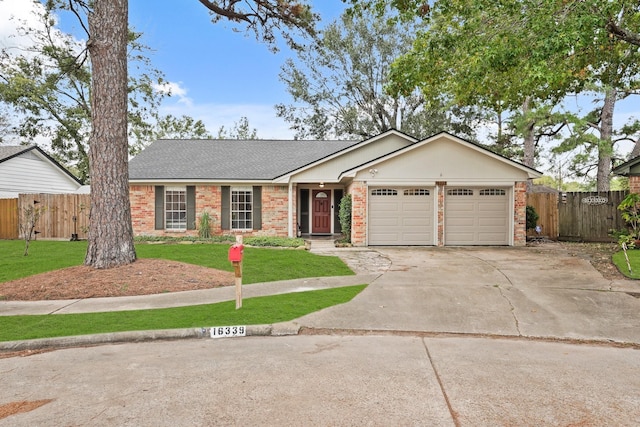 ranch-style home featuring a front yard, concrete driveway, brick siding, and fence