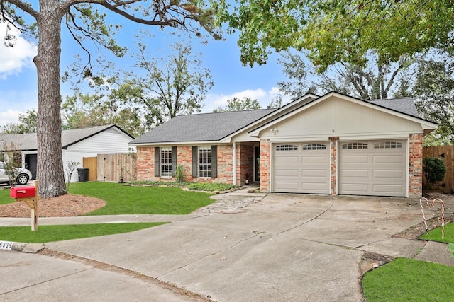 single story home featuring a garage, driveway, a front yard, and brick siding