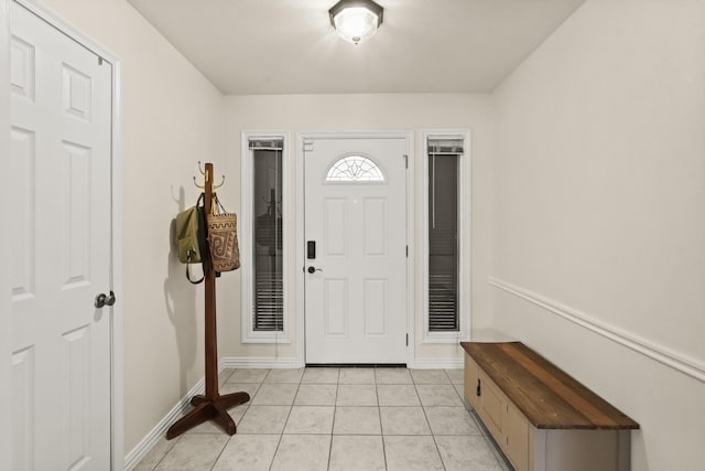 foyer entrance with light tile patterned floors and baseboards