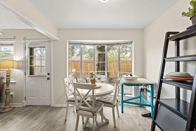 dining space with wood finished floors and baseboards