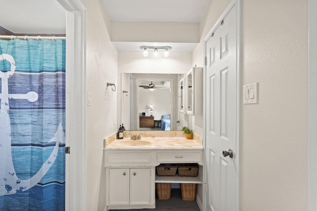 full bath with ensuite bathroom, ceiling fan, curtained shower, and vanity